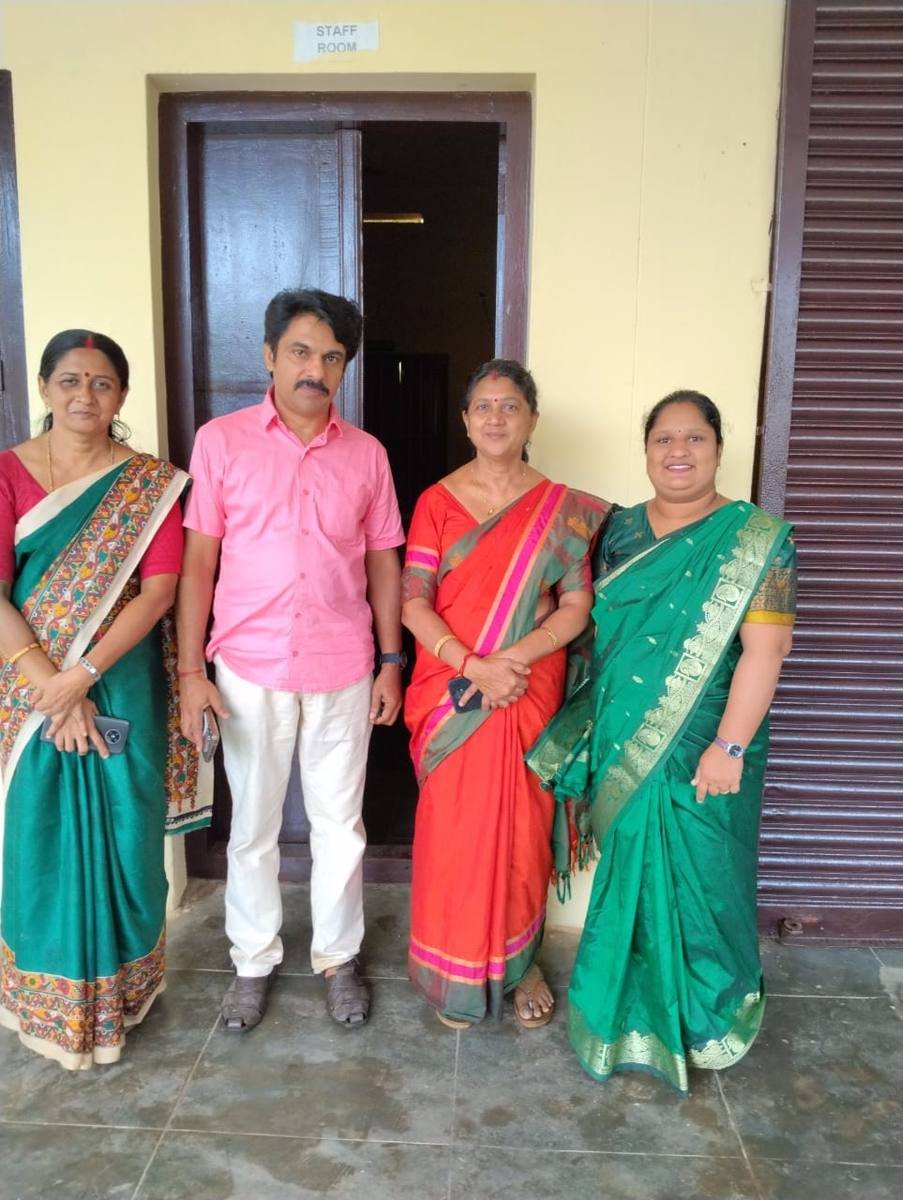 Four members of staff standing together outside the staff room.
