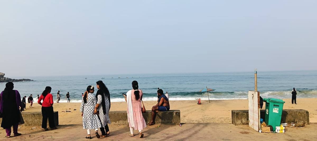 The party on the sea wall at Kovalam beach, the surf breaking beyond them.