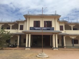 The front of the school building and its name board.