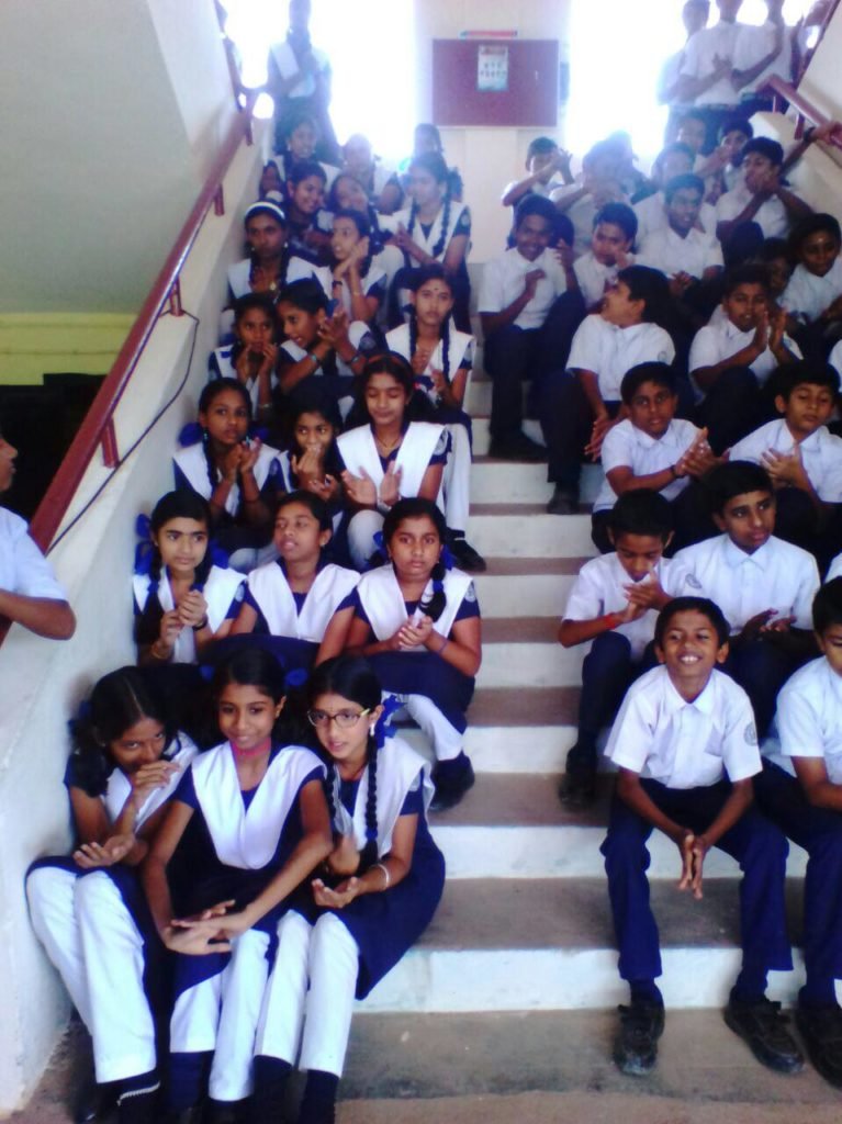 Students seated on the staircase during a school gathering.