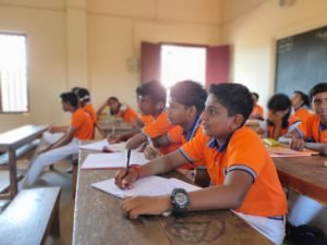 Senior pupils writing in their notebooks during a lesson.