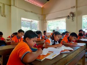 A primary class writing at their desks.